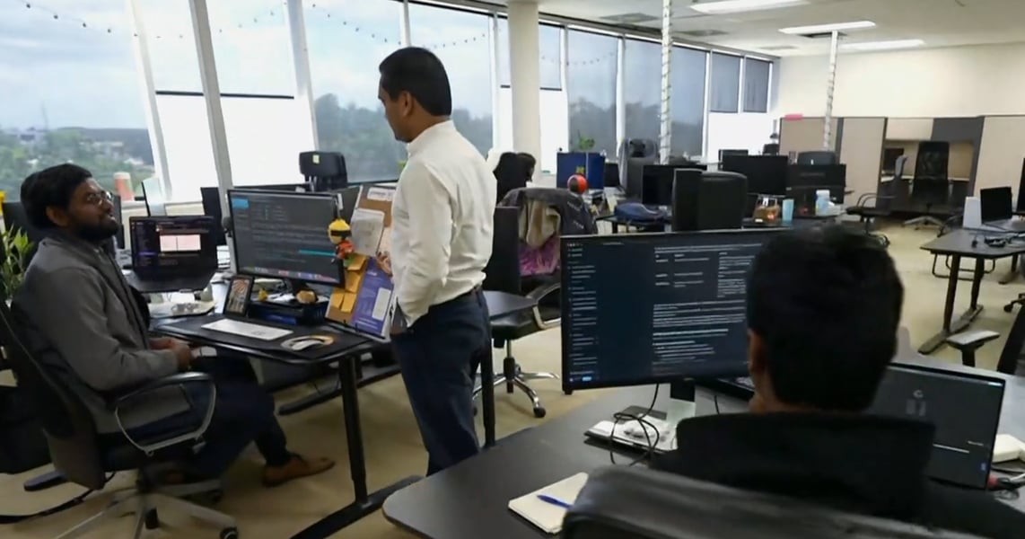 Business office workers discuss H-1B visa fee proposal uncertainty