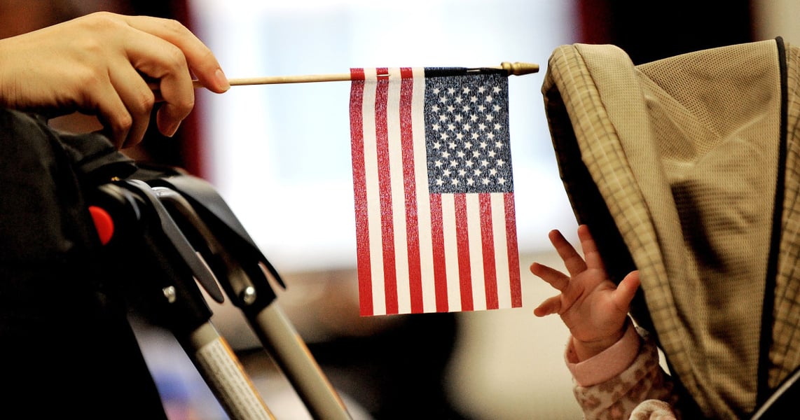 A baby wrapped in a US flag, symbolizing birthright citizenship rights blocked by federal judge ruling against Trump's executive order