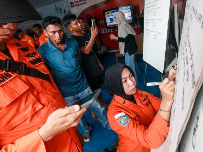 Rescue helicopter circles the inverted hull of the Indonesian ferry KM Virgo Transport 8 capsized in the Java Sea with 243 people aboard