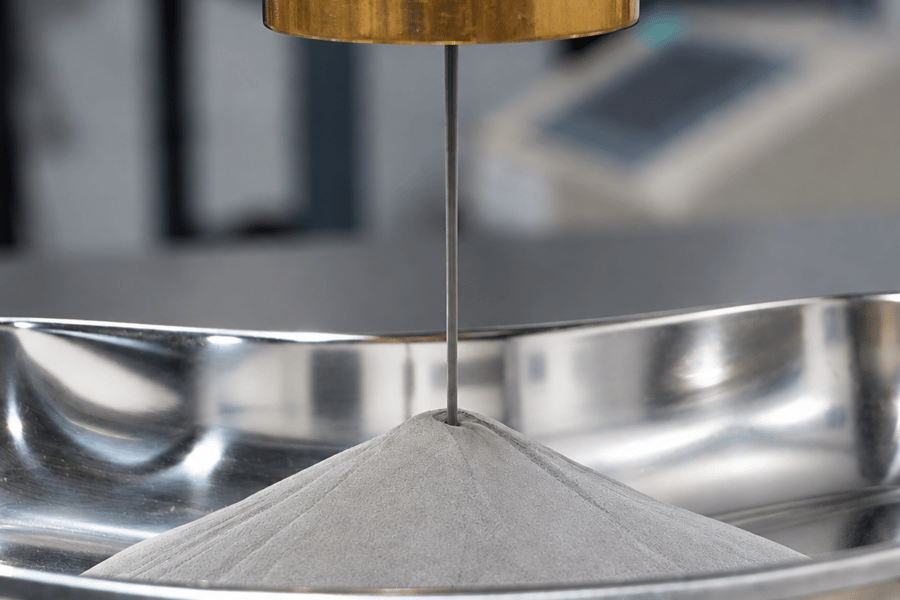 Image: titanium powder produced by PyroGenesis’ NexGen™ plasma atomization system flows into a tray.