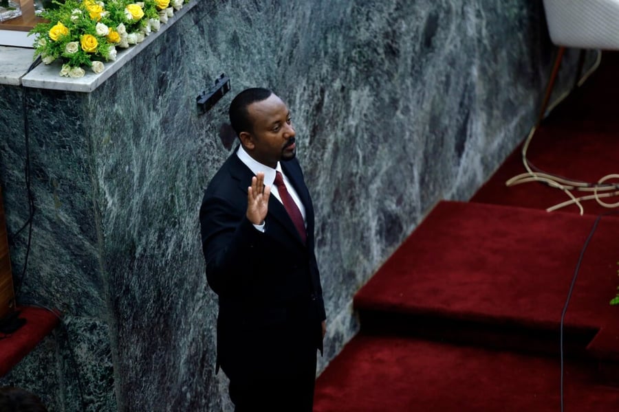 Ethiopian Prime Minister Abiy Ahmed raising his right hand as he takes the oath of office in parliament