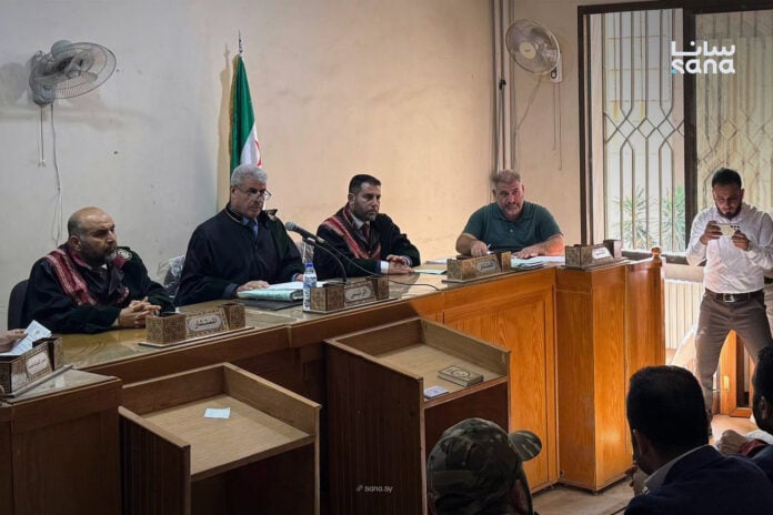 Judges and court officials seated at the bench during a hearing in the coastal events case at the court in Aleppo, Syria