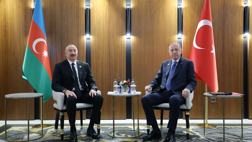Presidents Ilham Aliyev of Azerbaijan and Recep Tayyip Erdogan of Turkey seated between their national flags