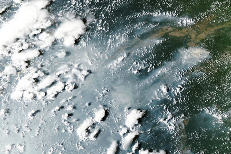 Satellite view of grey smoke plumes streaming across the Amazon River and rainforest from fires near Manaus and Santarem on October 12, 2026