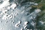 Satellite view of grey smoke plumes streaming across the Amazon River and rainforest from fires near Manaus and Santarem on October 12, 2026