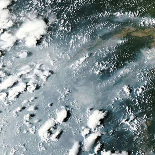 Satellite view of grey smoke plumes streaming across the Amazon River and rainforest from fires near Manaus and Santarem on October 12, 2026