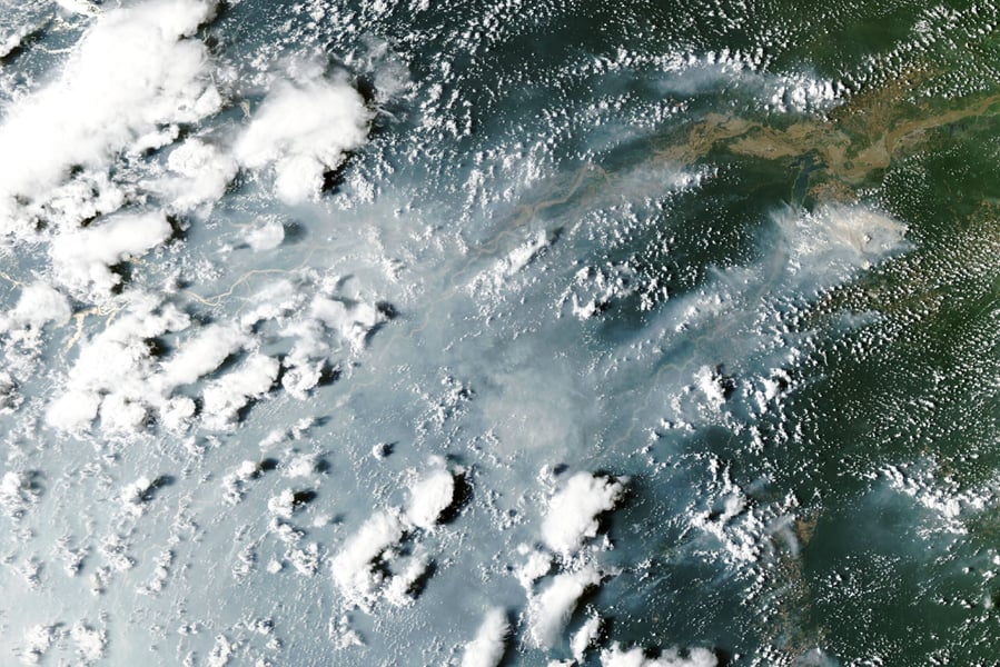 Satellite view of grey smoke plumes streaming across the Amazon River and rainforest from fires near Manaus and Santarem on October 12, 2026