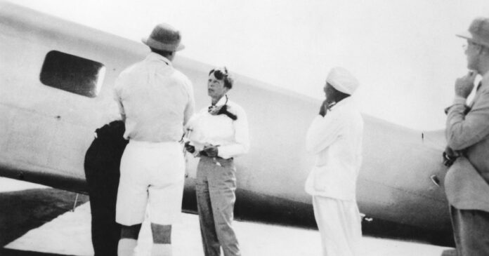 Black-and-white archive photograph of Amelia Earhart standing beside her Lockheed Electra in Khartoum