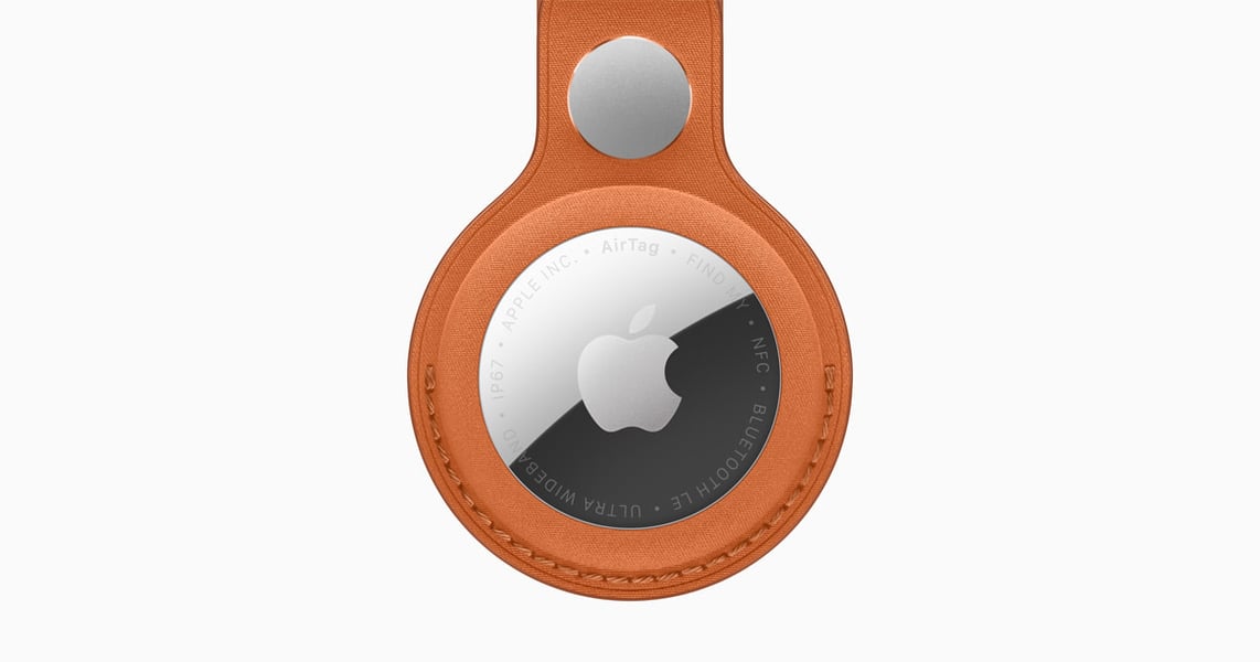 Apple AirTag shown with a FineWoven key-ring accessory in official promotional imagery