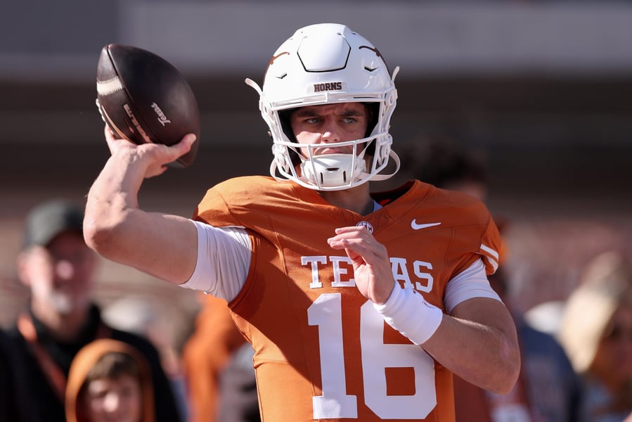Texas quarterback Arch Manning in an orange No. 16 jersey and white helmet throws a football during pregame warmups