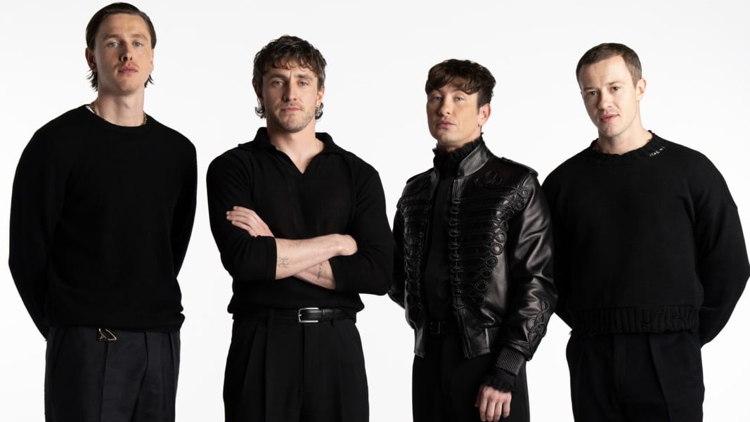 Four actors cast as the Beatles in Sam Mendes' films stand side by side in black clothing against a white backdrop