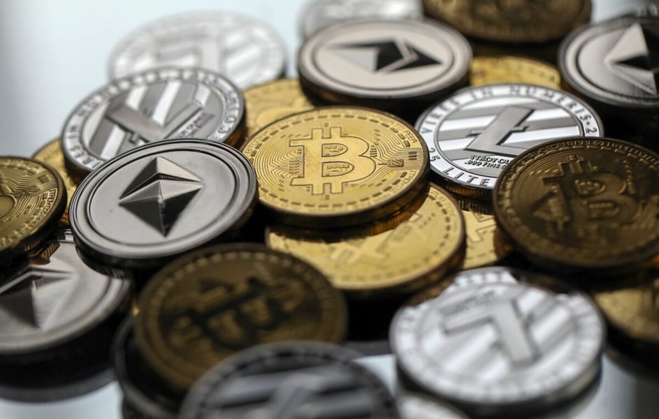 Close-up of physical Bitcoin, Ether and other cryptocurrency tokens piled together