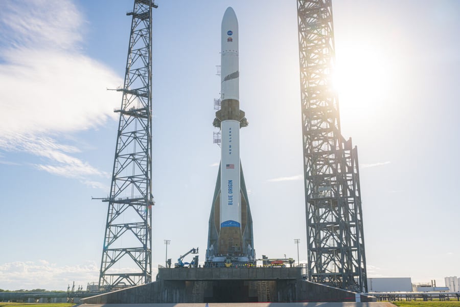 Blue Origin's New Glenn rocket standing upright on its pad between two lightning towers at Launch Complex 36 in Florida