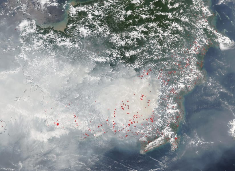 Satellite view of Borneo on October 15, 2026 with grey smoke over the south and red dots marking thermal anomalies detected by VIIRS