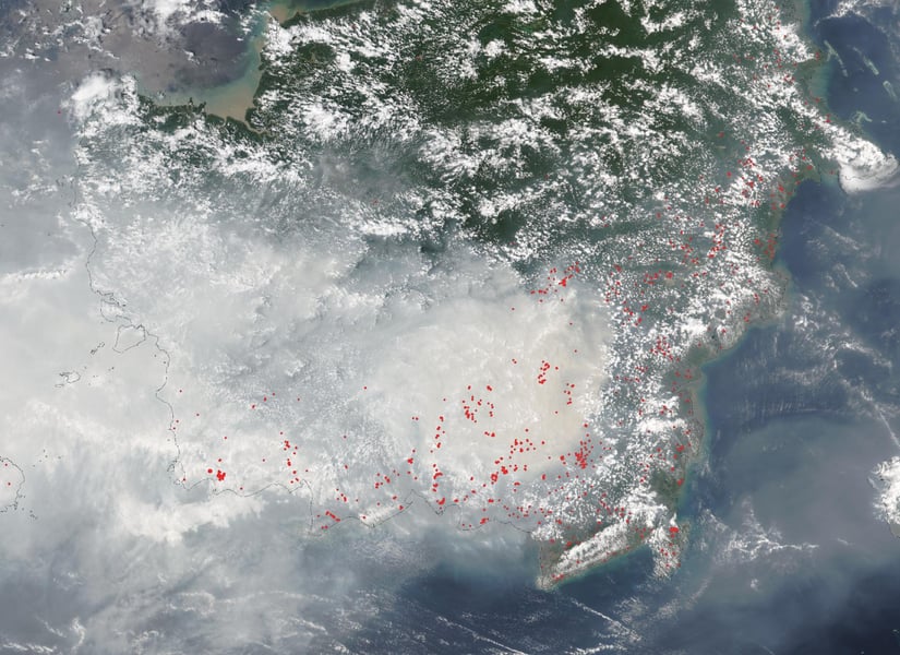 Satellite view of Borneo on October 15, 2026 with grey smoke over the south and red dots marking thermal anomalies detected by VIIRS