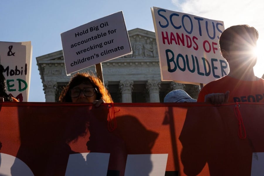Demonstrators hold signs reading Hold Big Oil accountable and SCOTUS hands off Boulder outside the US Supreme Court