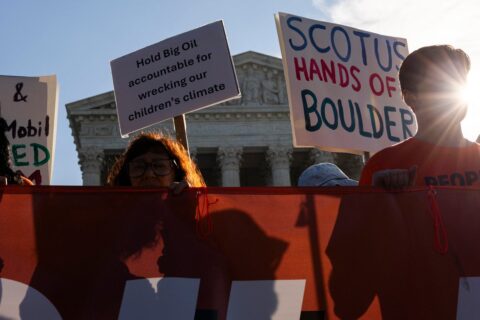 Demonstrators hold signs reading Hold Big Oil accountable and SCOTUS hands off Boulder outside the US Supreme Court