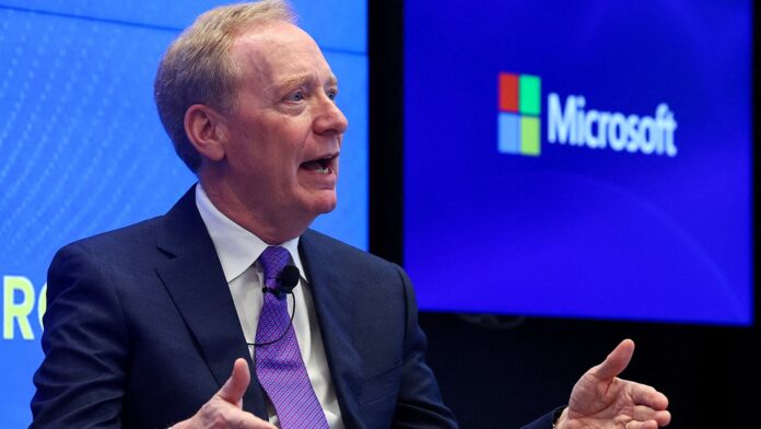 Microsoft president Brad Smith speaking in front of a Microsoft logo