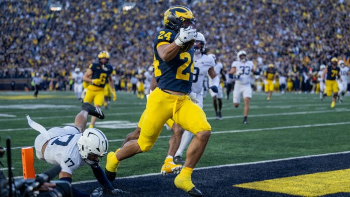 Michigan's Bryson Kuzdzal carries the ball toward the end zone against Penn State at Michigan Stadium