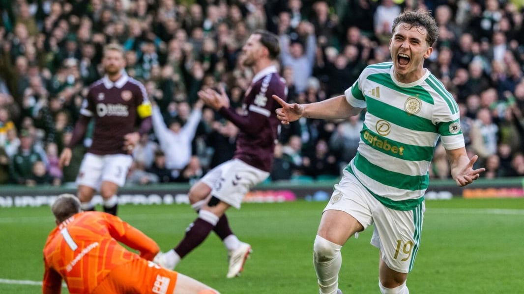 A Celtic player in green and white hoops celebrates in front of dejected Hearts players and their goalkeeper at Celtic Park