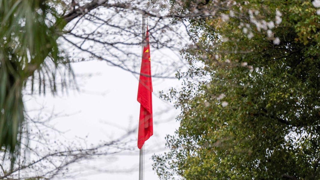 The Chinese national flag on a flagpole among trees at the Chinese embassy in Japan