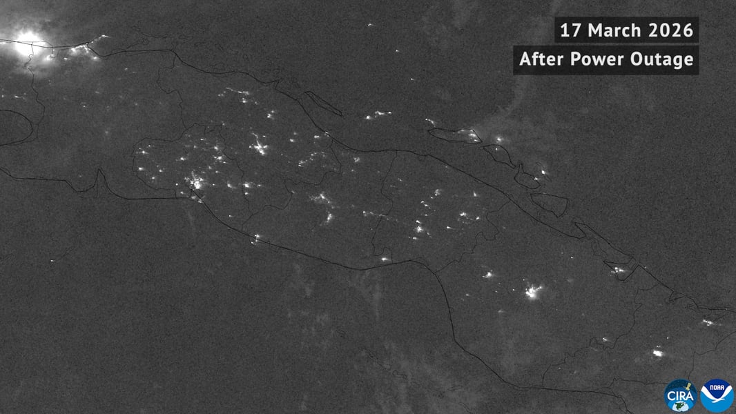 Grayscale satellite view of Cuba at night on 17 March 2026 after a power outage, with only scattered city lights visible