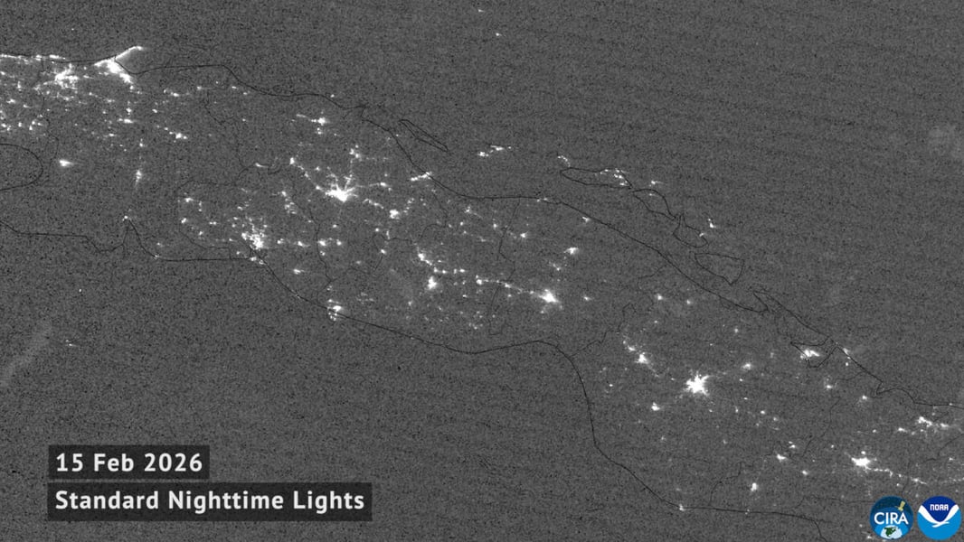 Grayscale satellite view of Cuba at night on 15 February 2026 with city lights glowing across the island