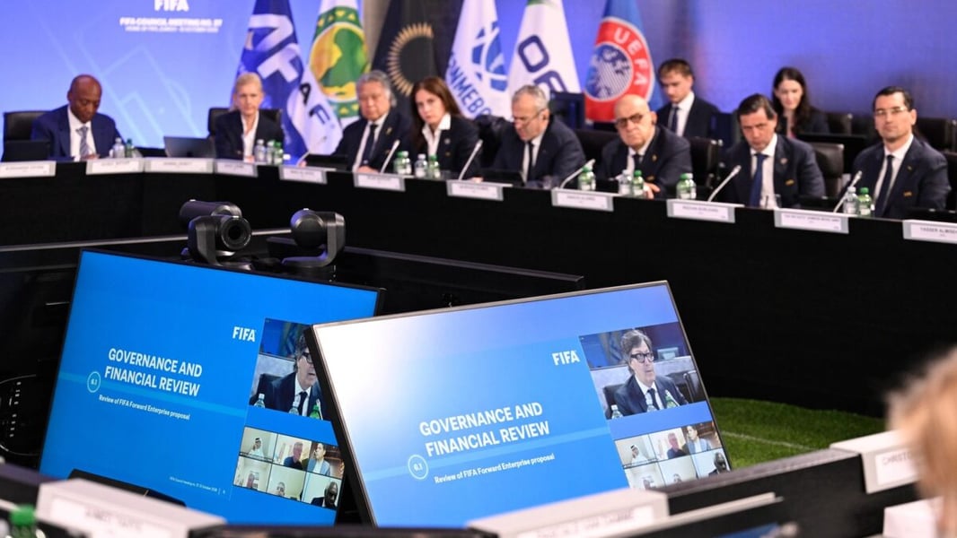 Council members seated behind confederation flags at FIFA Council meeting no. 37 in Zurich, with screens in the foreground showing a Governance and Financial Review of the FIFA Forward Enterprise proposal
