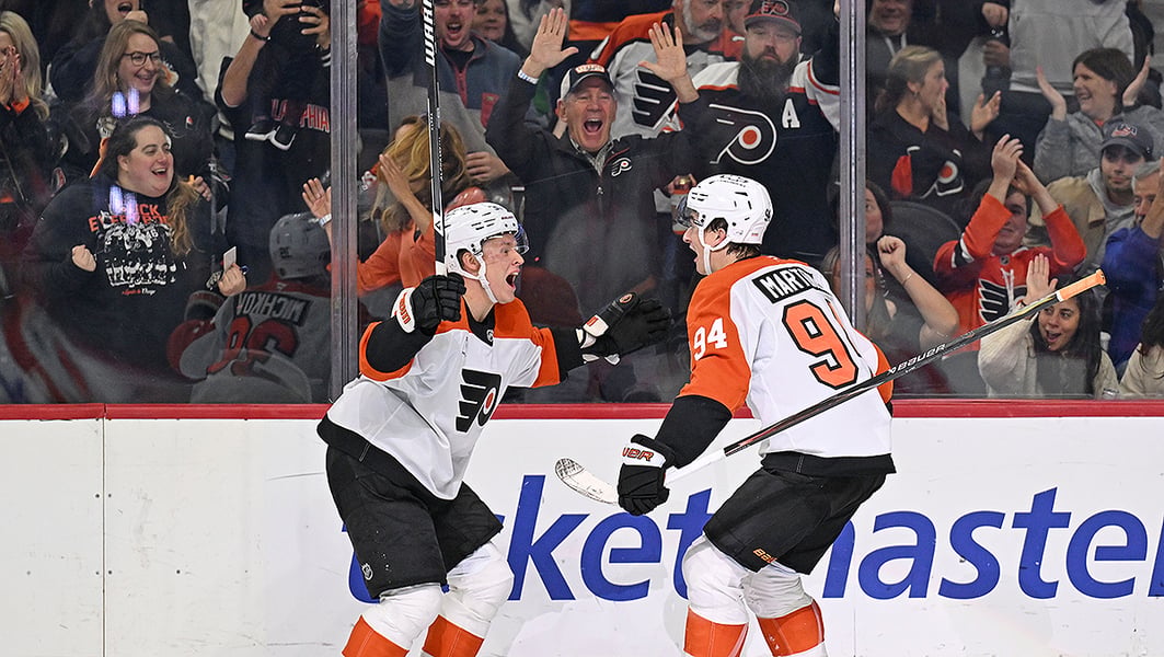 Philadelphia Flyers forwards Porter Martone and Matvei Michkov celebrate as fans cheer behind the glass