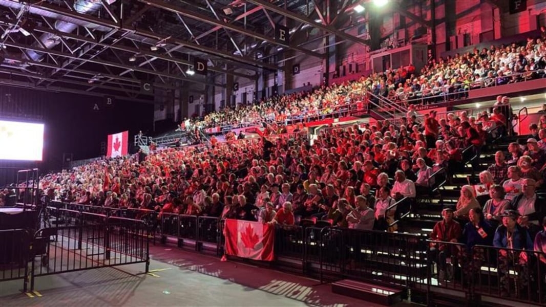 Supporters fill the stands and hold Canadian flags at a Forever Canadian rally in Edmonton