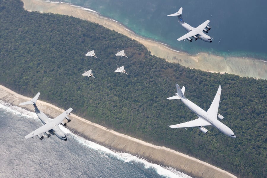 Four Rafale fighters in formation with two A400M transports and an A330 tanker over an Indonesian coastline