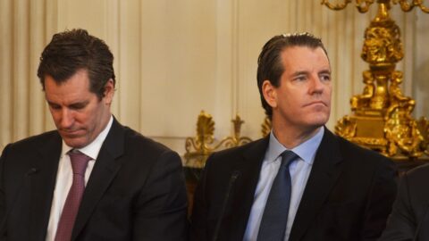 Gemini co-founders Cameron and Tyler Winklevoss seated side by side in a gilded room