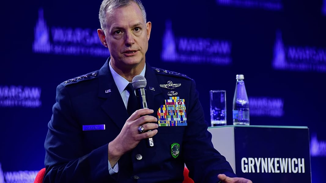 Gen. Alexus Grynkewich holding a microphone on a panel at the Warsaw Security Forum