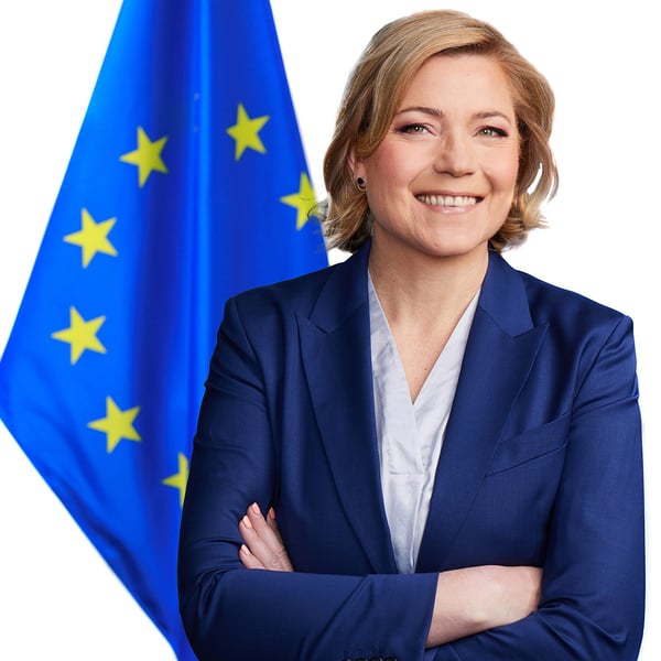 Henna Virkkunen, the European Commission's Executive Vice-President for Tech Sovereignty, Security and Democracy, in an official portrait beside an EU flag