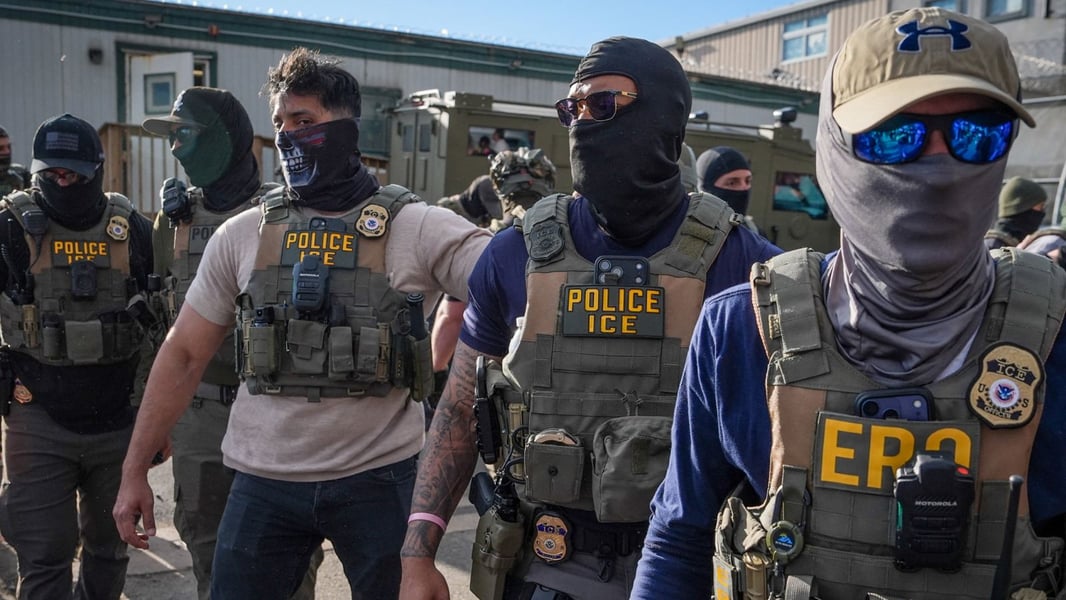 Masked federal immigration agents including ICE officers during an enforcement operation