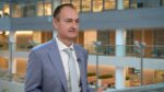 An IMF official speaking in an office atrium in the IMF's video release of the October 2026 Global Financial Stability Report