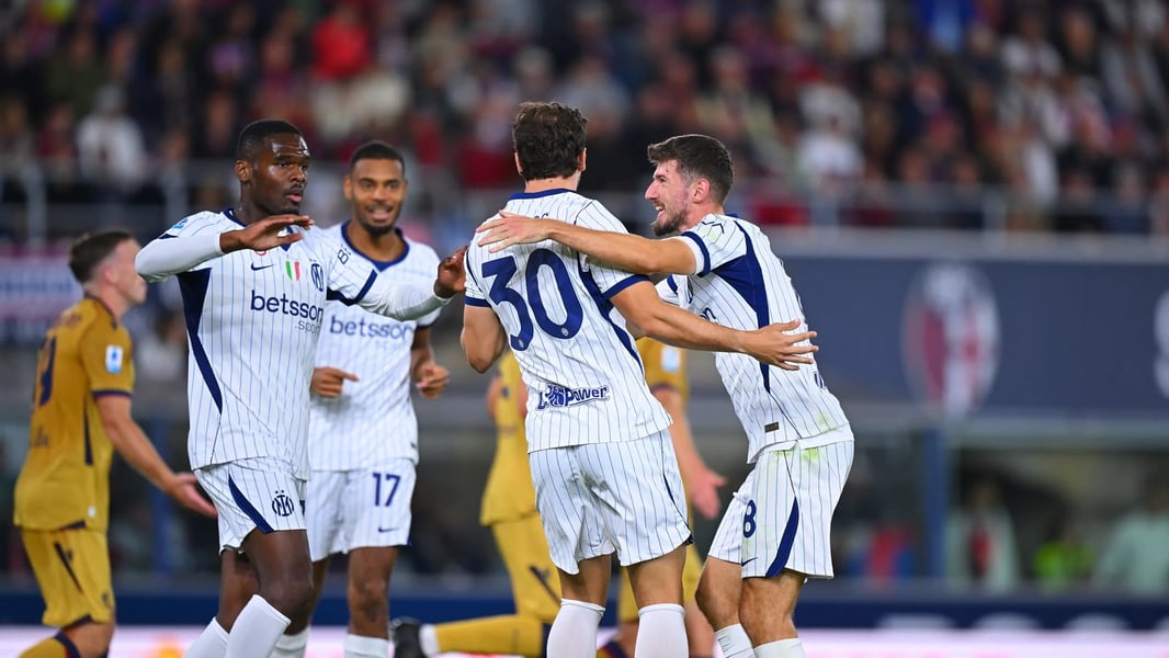 Inter wing-back Carlos Augusto, number 30, celebrates with teammates after scoring at Bologna in white away shirts