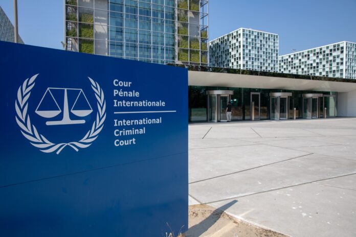 Entrance of the International Criminal Court headquarters in The Hague beside its blue sign