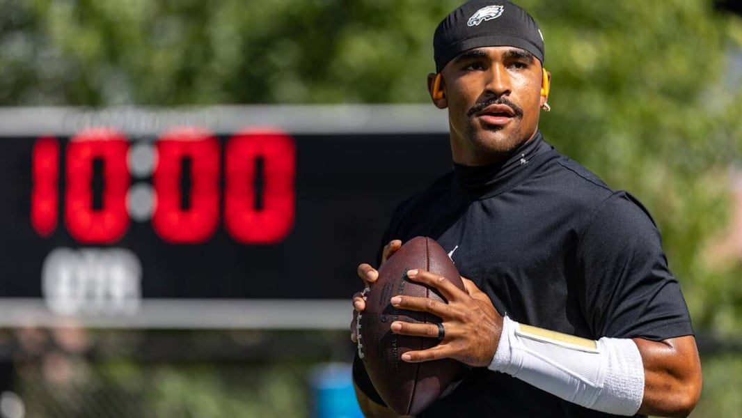 Eagles quarterback Jalen Hurts holds a football in a black training top in a file photo