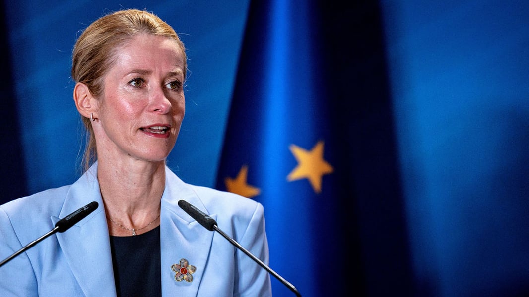 EU foreign policy chief Kaja Kallas speaking at a lectern in front of an EU flag