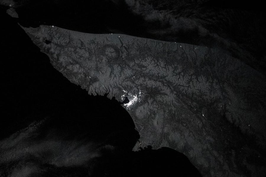 Night view from orbit of the snow-covered Kamchatka Peninsula with the bright lights of Petropavlovsk-Kamchatsky on the southeast coast