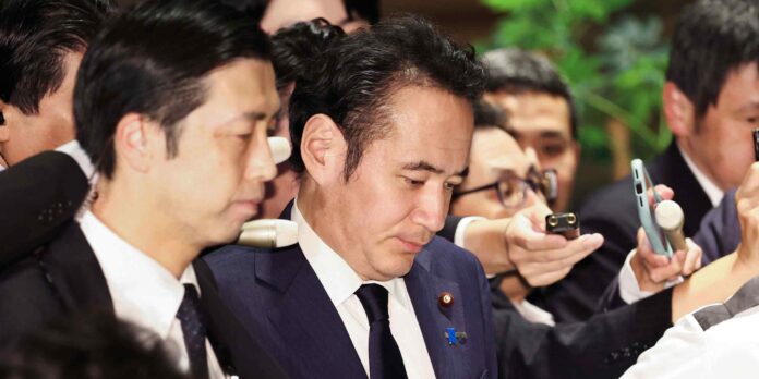 Agriculture Minister Kazuo Yana surrounded by reporters and microphones at the Prime Minister's Office in Tokyo on October 14, 2026