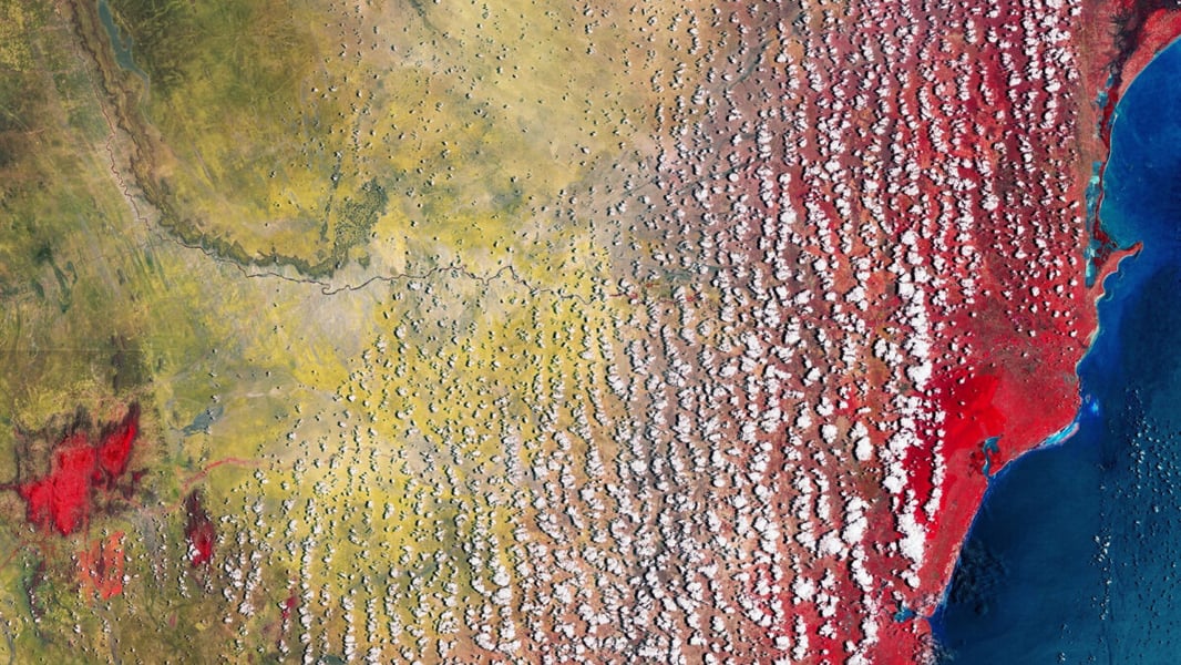 False-colour satellite image of Kenya's coast near Malindi, with vegetation in red, scattered clouds and the Indian Ocean in blue