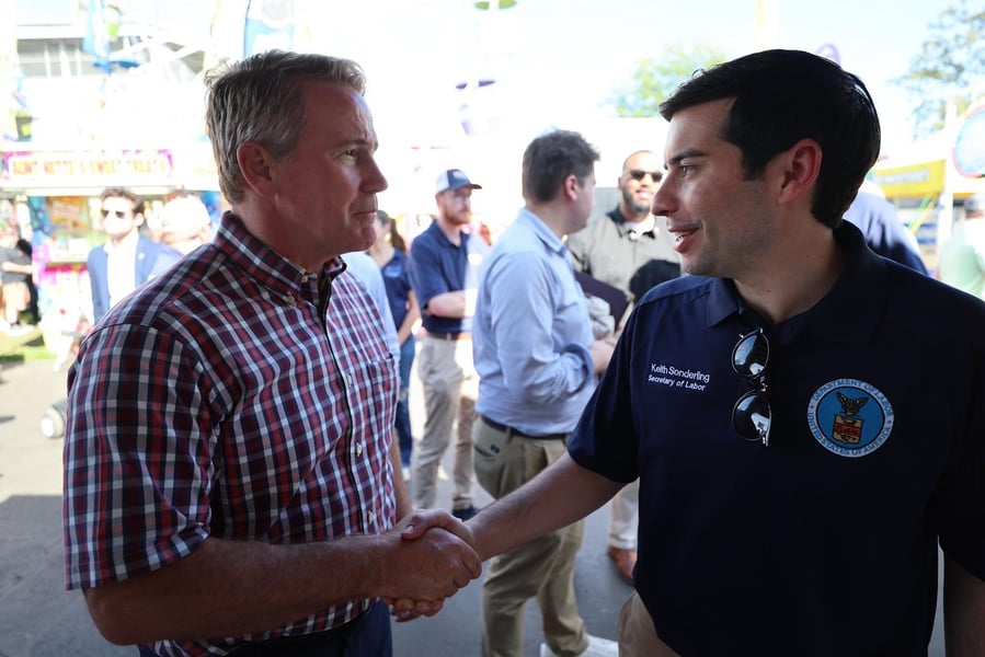 Labor Secretary Keith Sonderling in a Department of Labor polo shakes hands with a man in a plaid shirt at the Fulton County Fair in northwest Ohio
