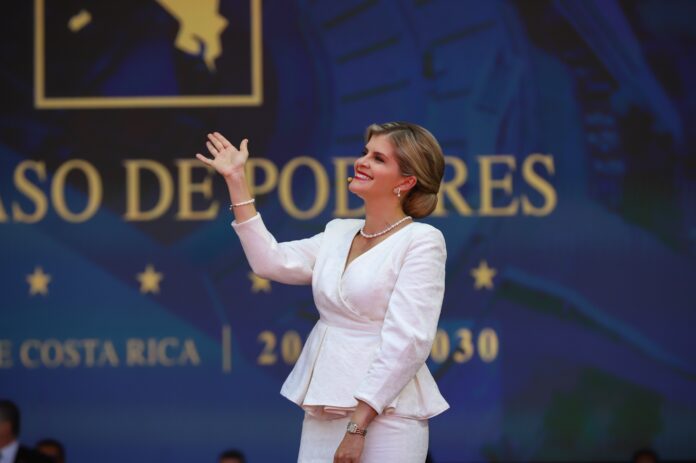 Costa Rican President Laura Fernandez waving on stage at a transfer-of-power ceremony