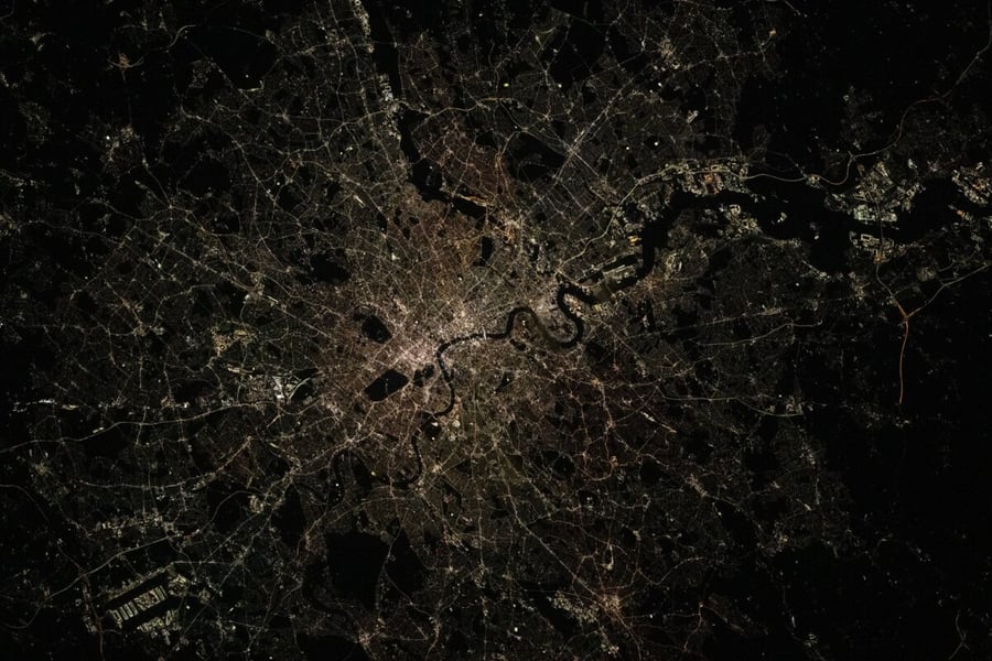 London photographed at night from orbit, with the River Thames and the city's street lights visible