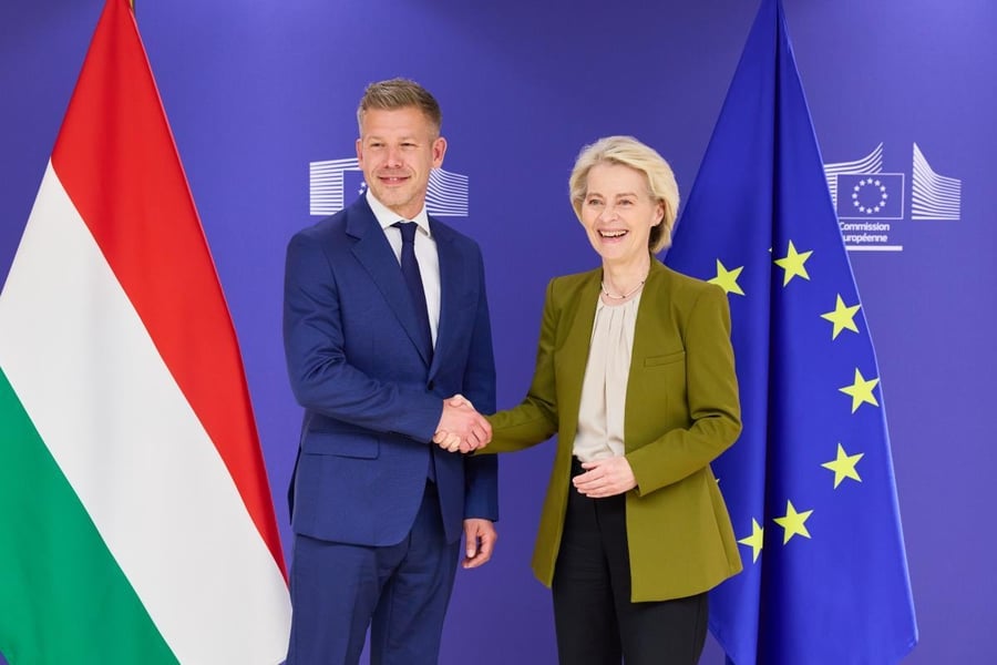 Hungarian Prime Minister Peter Magyar and European Commission President Ursula von der Leyen shake hands in front of Hungarian and EU flags