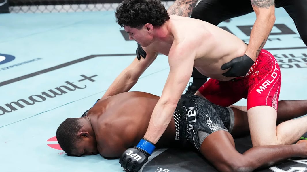 Joaquin Buckley lies face down on the canvas as Mike Malott leans over him after the knockout at UFC Edmonton