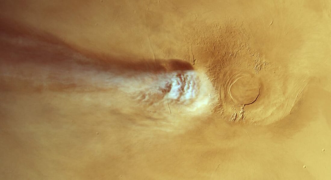White water ice cloud streaming from the Arsia Mons volcano across the tan surface of Mars, seen from above by Mars Express