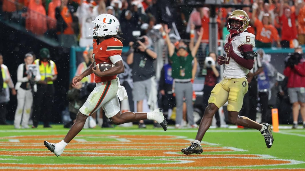 A Miami player carries the ball through the end zone as a Florida State defender trails during Saturday's game.